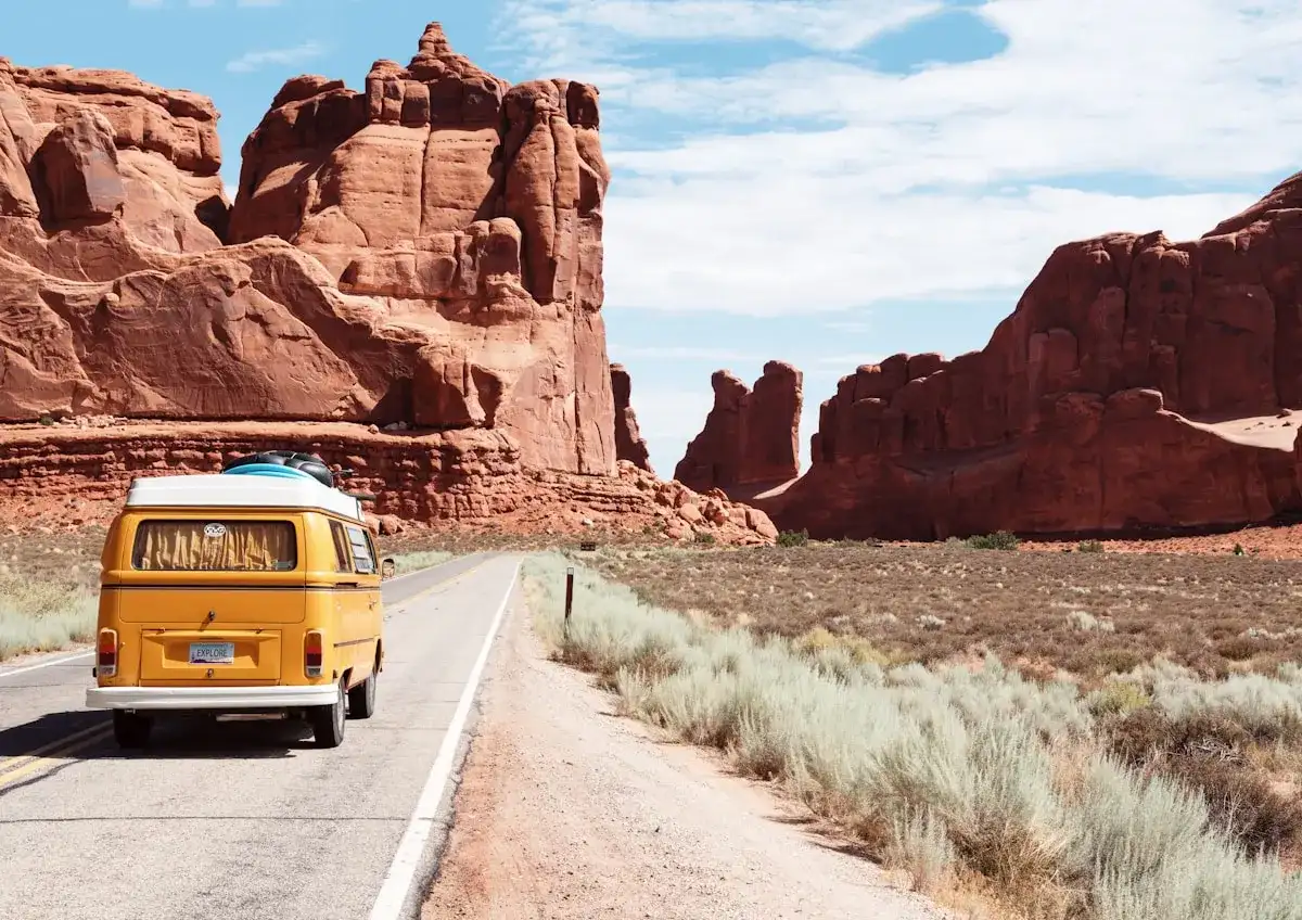 Camper van on a road through red rock scenery