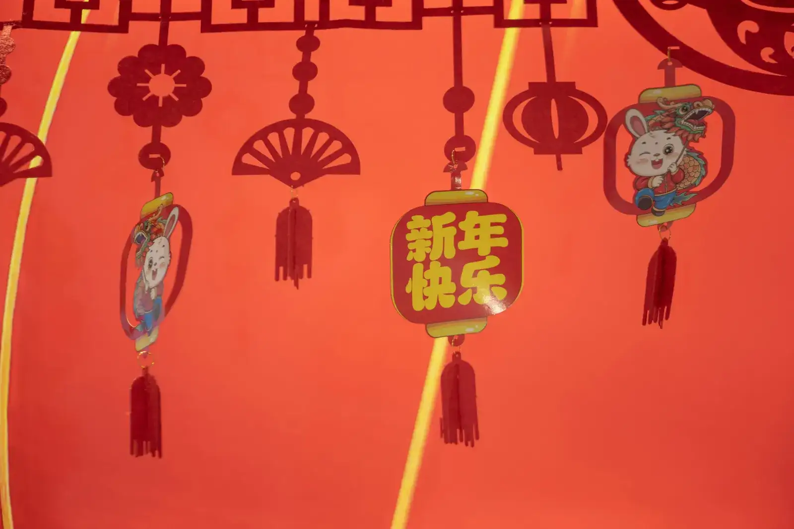 a red wall with chinese decorations hanging from it's sides