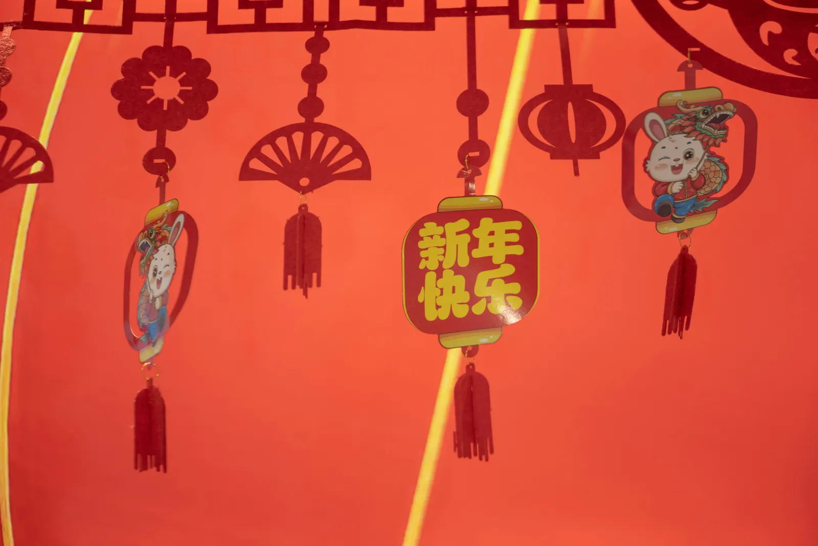 a red wall with chinese decorations hanging from it's sides